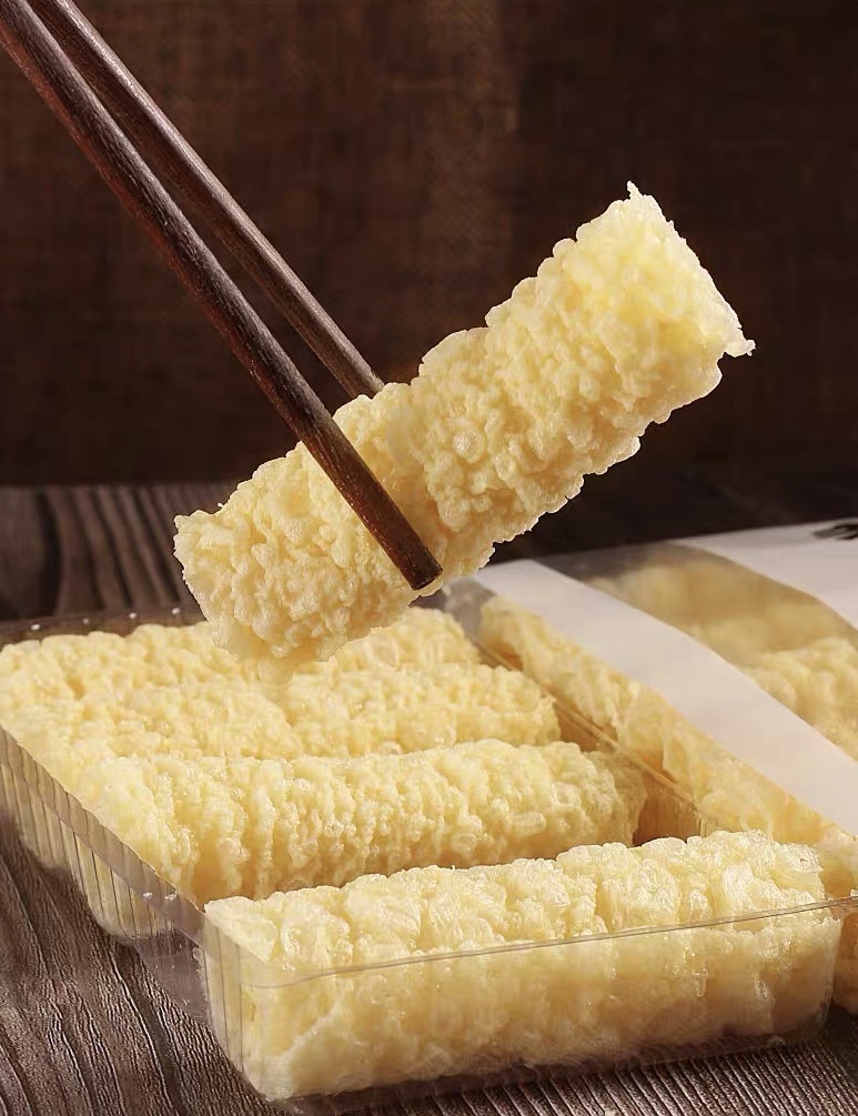 Fried tofu skin rolls served with chopsticks