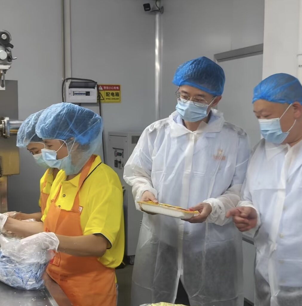 Workers conduct quality inspection at a soy food packaging line